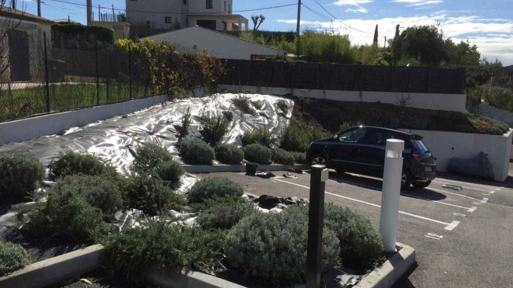 Pose d'une toile horticole dans un talus à côté d'un parking à la gaude